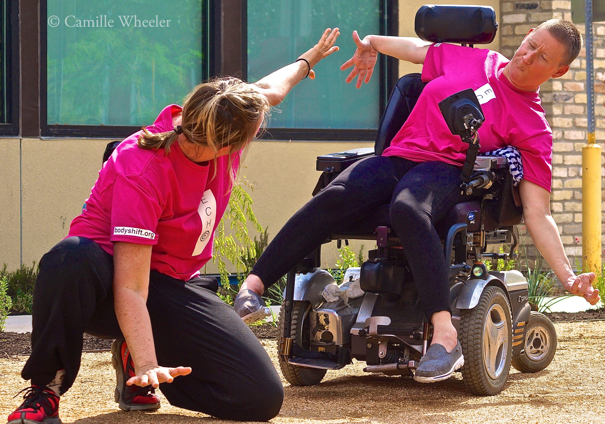 Two dancers with and without disabilities performing outdoors.